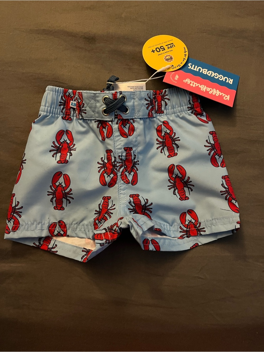 RuffleButts Light Blue Swim Trunks with Red Lobster Print